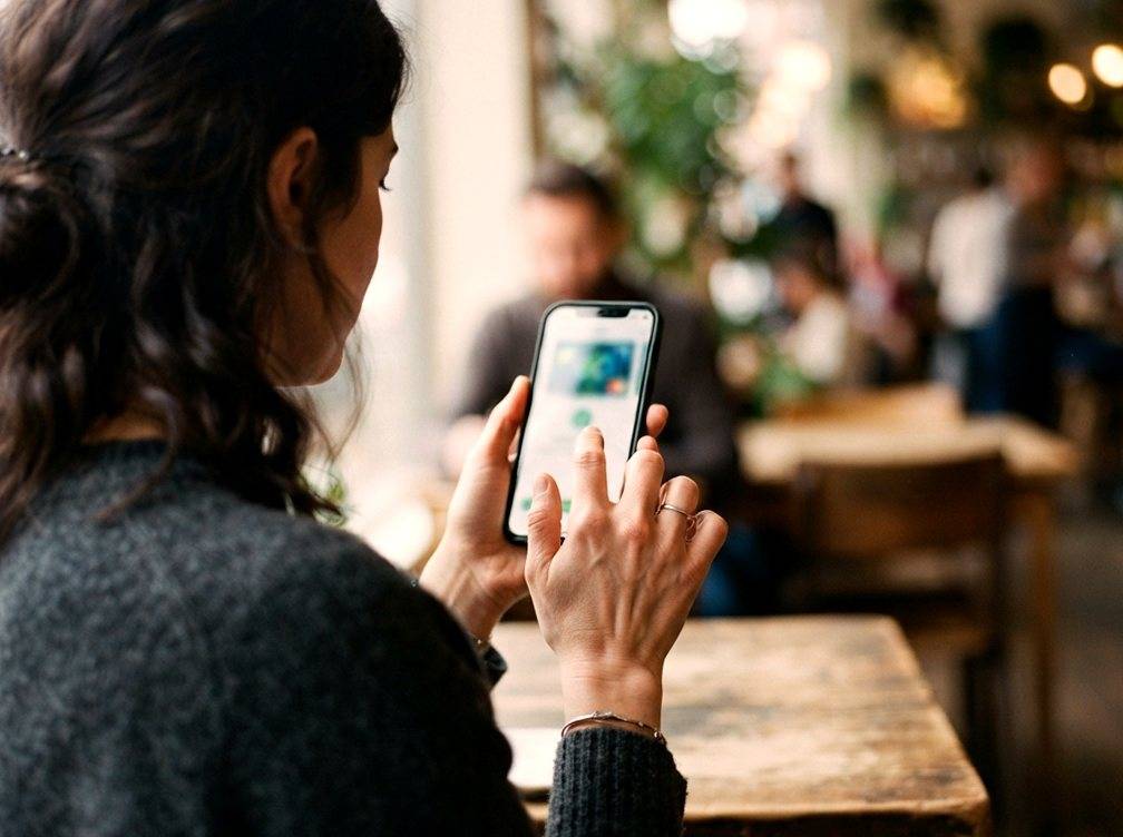 Close up of a hand tapping a smartphone screen to confirm a bank transfer.